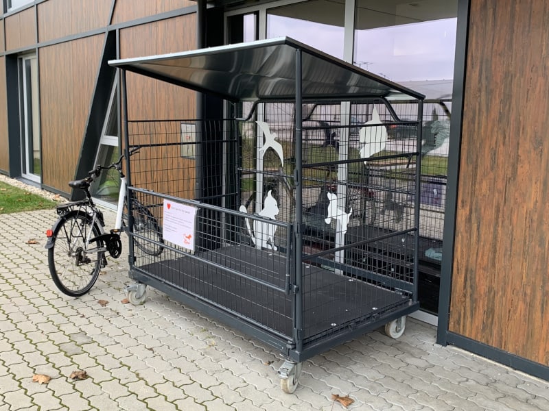 Eine große, orangene Box steht vor dem Haupteingang des TierQuarTiers Wien.