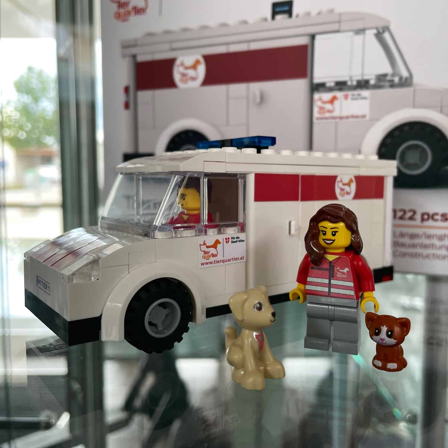 TierQuarTier Lego Auto Eine Katze sitzt auf einem Sessel und greift mit der Pfote zur Kamera.